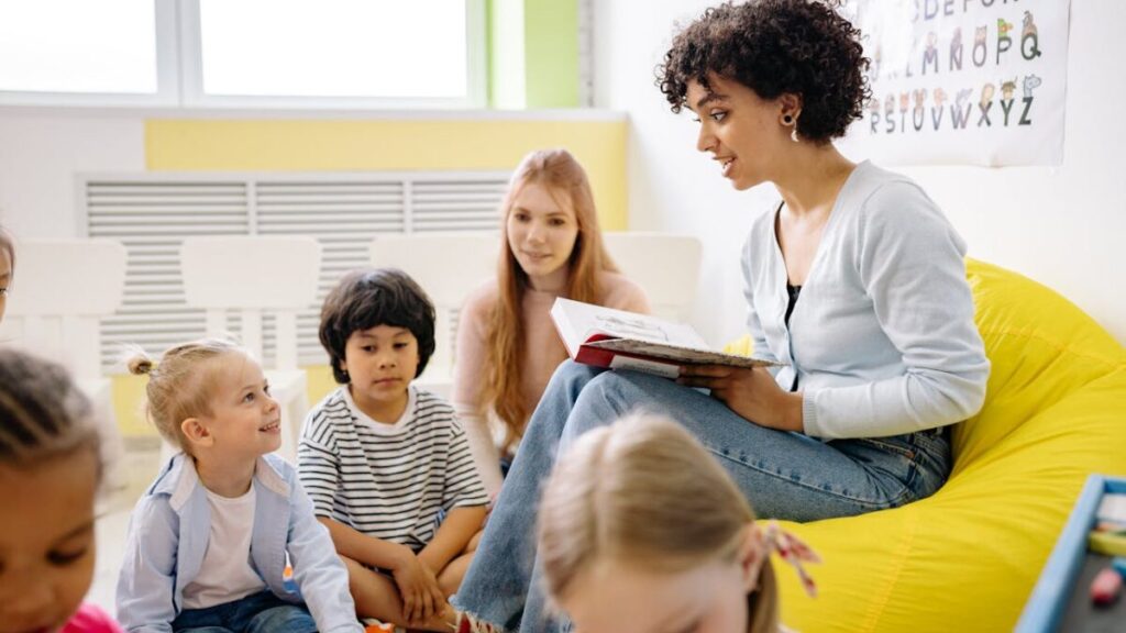 Professora lendo história para crianças na pré-escola durante atividade de socialização infantil